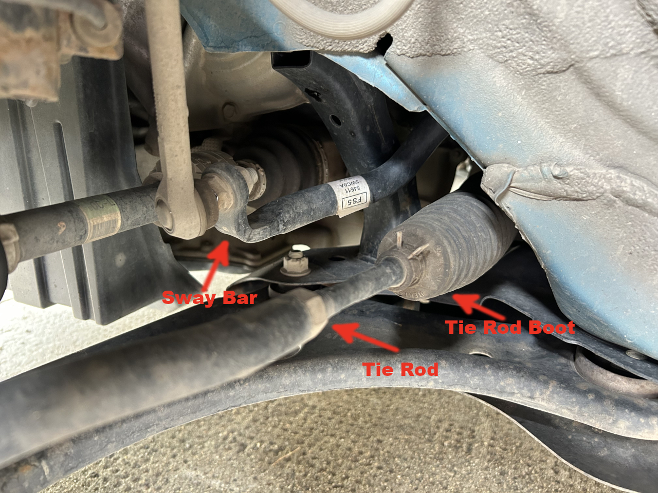 A Picture of a car’s tie rod and boot connecting it to the steering box.